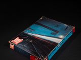 un livre ouvert posé sur une table, sur une surface noire