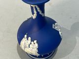 un vase bleu orné de motifs blancs, posé sur une table