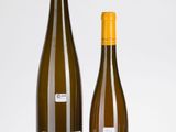deux bouteilles de vin posées l'une à côté de l'autre sur une surface blanche
