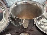 a silver plate with a silver cup and spoons on it