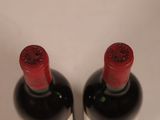 two bottles of wine sitting next to each other on a table