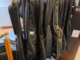 une valise à laquelle sont suspendues plusieurs vestes