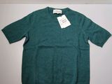 the sweater is green and has a tag on it