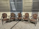 four chairs are sitting in front of a window with shutters
