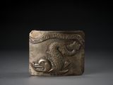 une image représentant une boucle de ceinture en bronze ornée d'un ours et d'un poisson