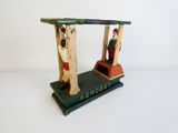 a small wooden toy train with a man sitting on it