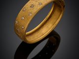 gros plan d'une bague en or avec des diamants sur une surface noire