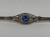 a close up of a blue stone and diamond broocher