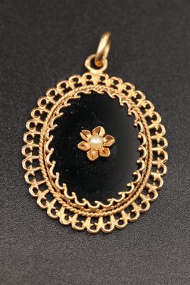 un pendentif doré et noir orné d'une fleur