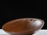 football shaped bowl on a white table with a black background