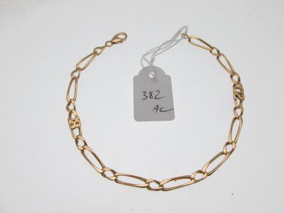 un gros plan sur un bracelet en chaîne dorée muni d'une étiquette de prix