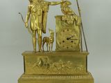 une statue en or représentant un homme avec un chien et une horloge