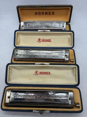 quatre harmonicas dans un étui, empilées les unes sur les autres