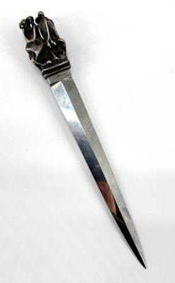 an image of a knife with a statue on it on a white surface