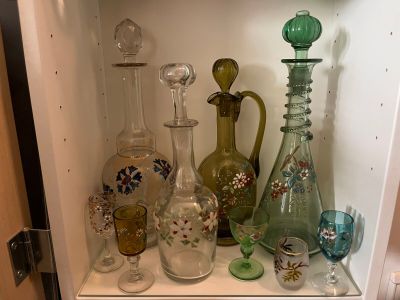 many different glass vases and glasses on the shelf