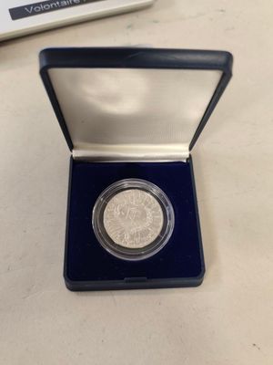 a small silver coin in a blue box on a table