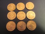 six types différents de pièces d'or sur une surface noire