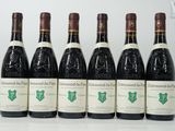 six bouteilles de vin sont alignées sur une table
