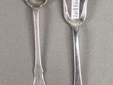 two spoons and a spoon that are on a table