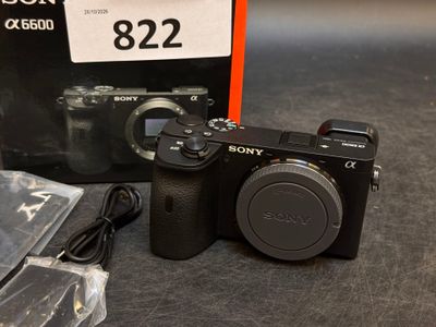 a sony camera with a box and a charger on the table