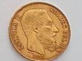 a close up of a gold coin on a white surface