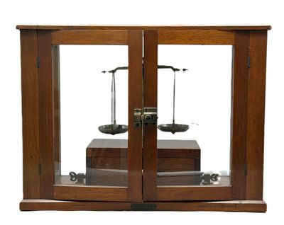 une vitrine en bois surmontée de deux balances