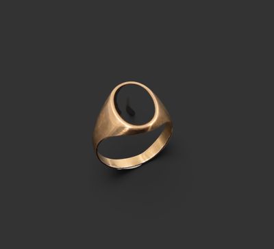 une bague en or avec une pierre noire au centre