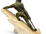 statue of a man on a rock with a spear in his hand