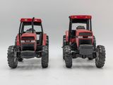 two red farm tractors side by side on a white background