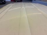 a white surfboard sitting in the middle of a garage