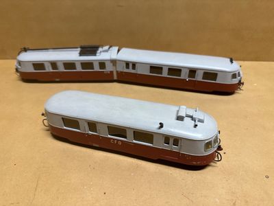 deux petits trains posés l'un à côté de l'autre sur une table