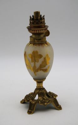un vase doré et blanc posé sur un socle et surmonté d'une couronne