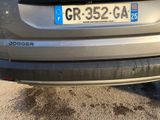 the rear end of a silver car with a number plate on it