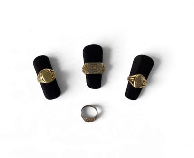 trois bagues en or et une bague sur un fond blanc