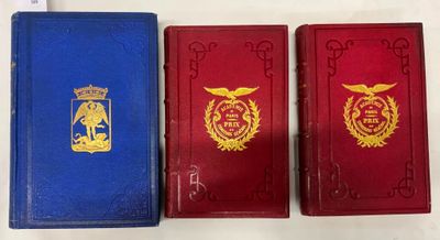 trois livres rouges et bleus posés sur une table blanche