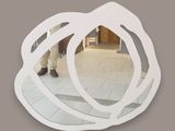 a man standing in front of a mirror that is shaped like a flower