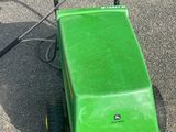 une tondeuse à gazon verte garée au milieu d'un parking