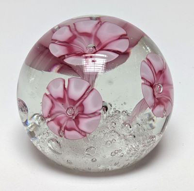une boule en verre contenant des fleurs roses