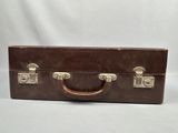 an old brown suitcase sitting on top of a white table