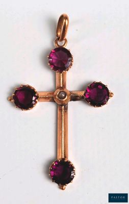 un gros plan d'une croix en or ornée de pierres violettes