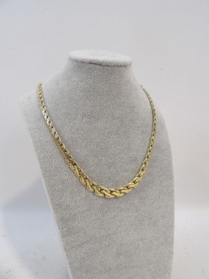 a gold chain necklace on a mannequin display