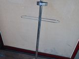 a metal pole that has a coat rack on it
