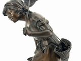 bronze statue of a woman with a basket of flowers on her head