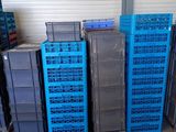 de nombreuses caisses bleues empilées les unes sur les autres dans un entrepôt