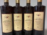 quatre bouteilles de vin sont alignées sur une table