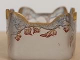 a close up of a silver bracelet with flowers on it
