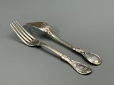 pair of silver plated forks and spoons on a gray surface