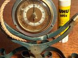une horloge posée sur une table, avec un tube de baume à lèvres à côté