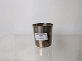 a silver cup sitting on a clear table