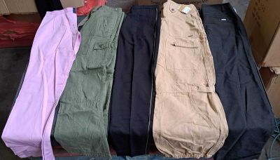 trois paires de pantalons cargo pour homme posées sur une boîte